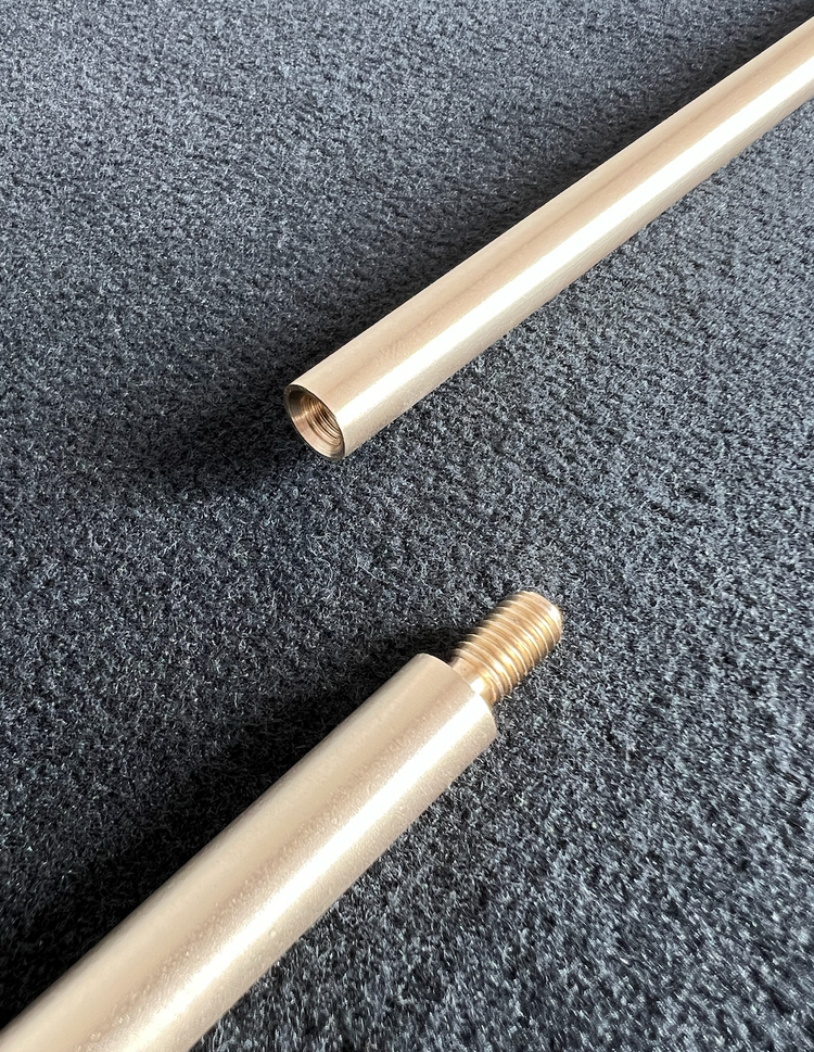 Two solid brass rods threading together — precision CNC-machined connection detail