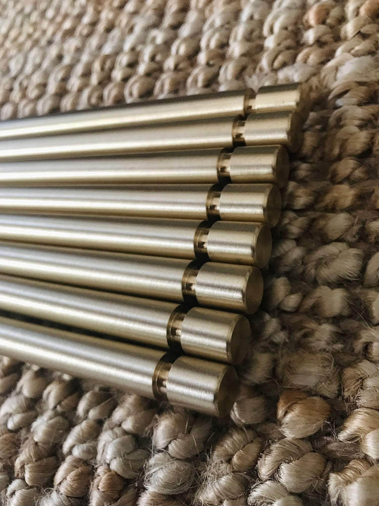 Solid brass rods with ceiling anchor groove — secure ceiling mounting detail