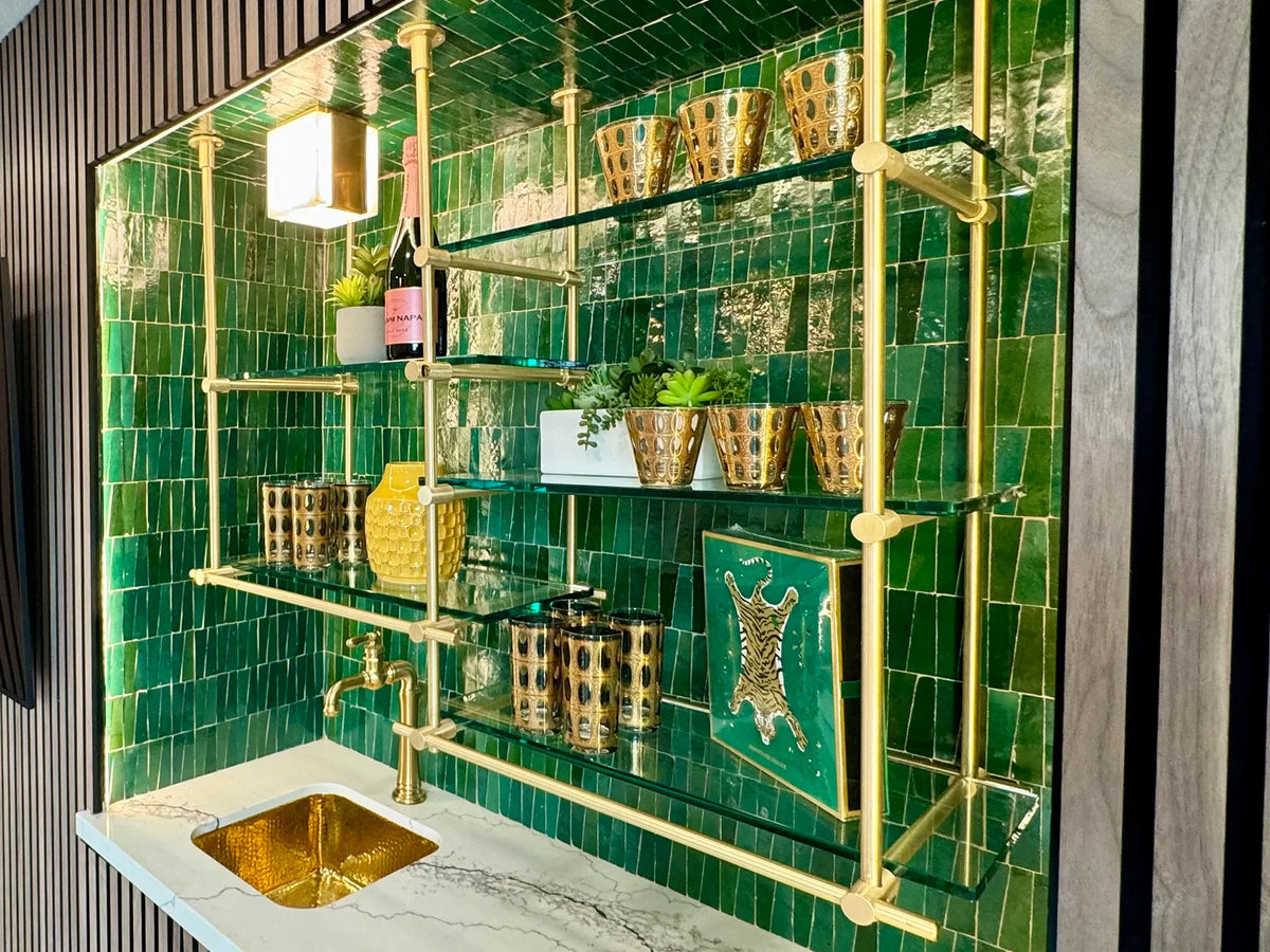 Custom ceiling-mounted brass shelving above a green tile bar in a kitchen, solid brass, BrassShelf