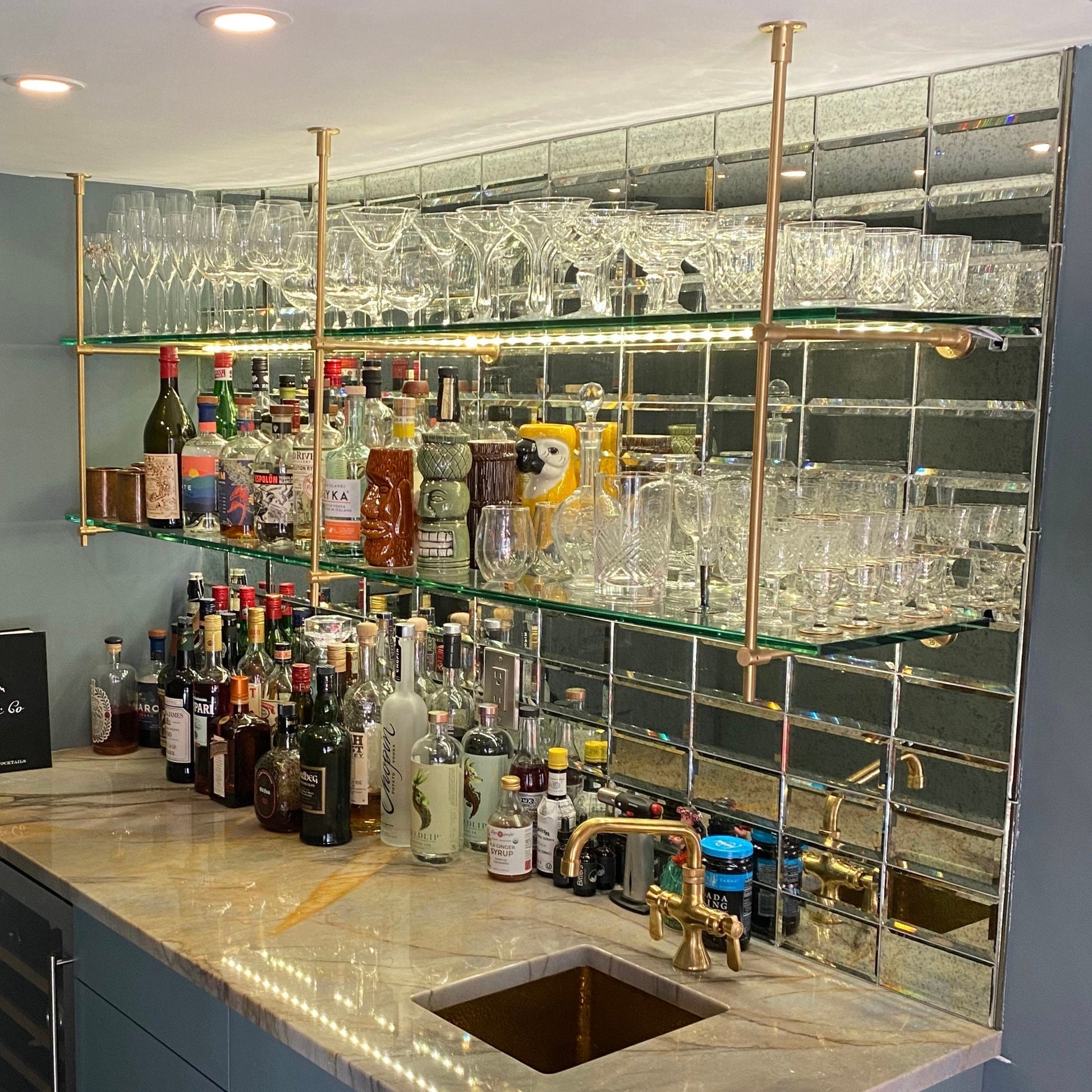 Industrial chic brass bar shelving with glass accents - Trendy industrial chic brass bar shelving adorned with glass accents, perfect for adding a modern edge to your bar area.